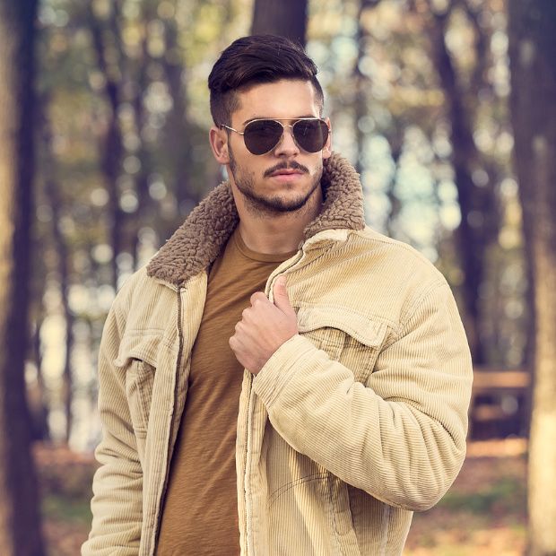 Stylish man with sunglasses posing in autumn park